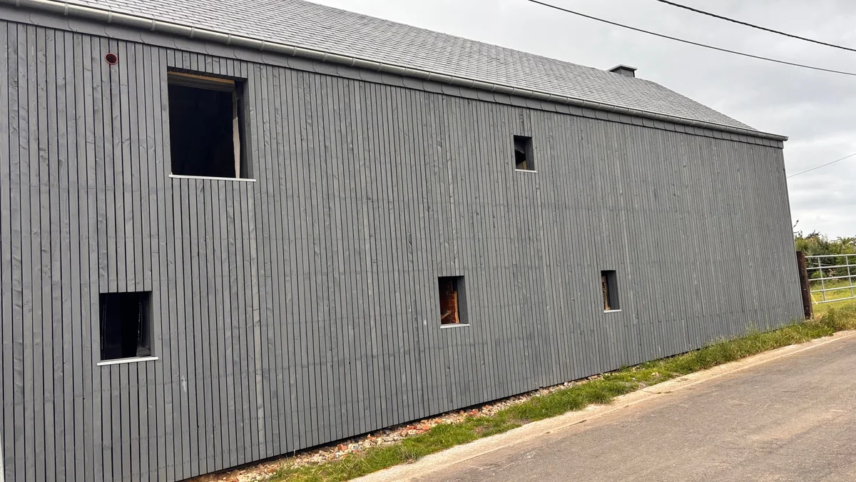 Ferme rénovée avec notre bardage en Mélèze de Pays traité par saturateur en gris foncé Quartz.