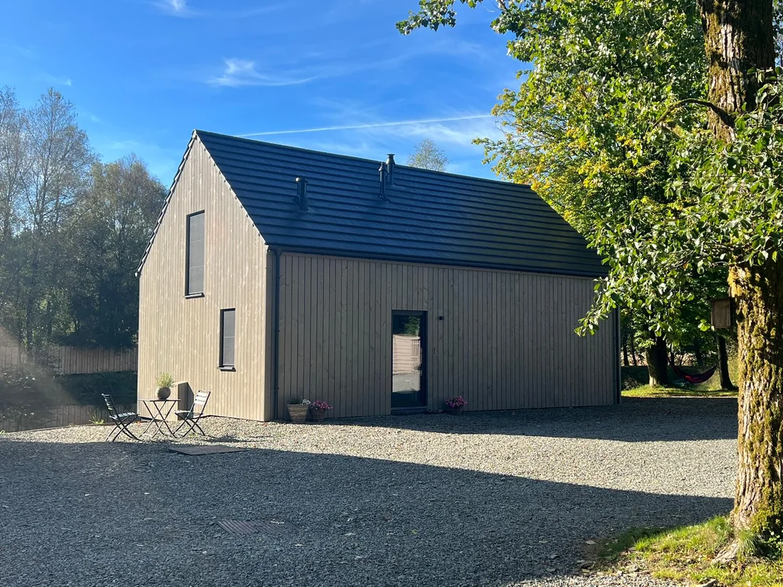 Chalets bardés en pin thermo-traité pré-grisé, pose verticale, au bord de l'eau