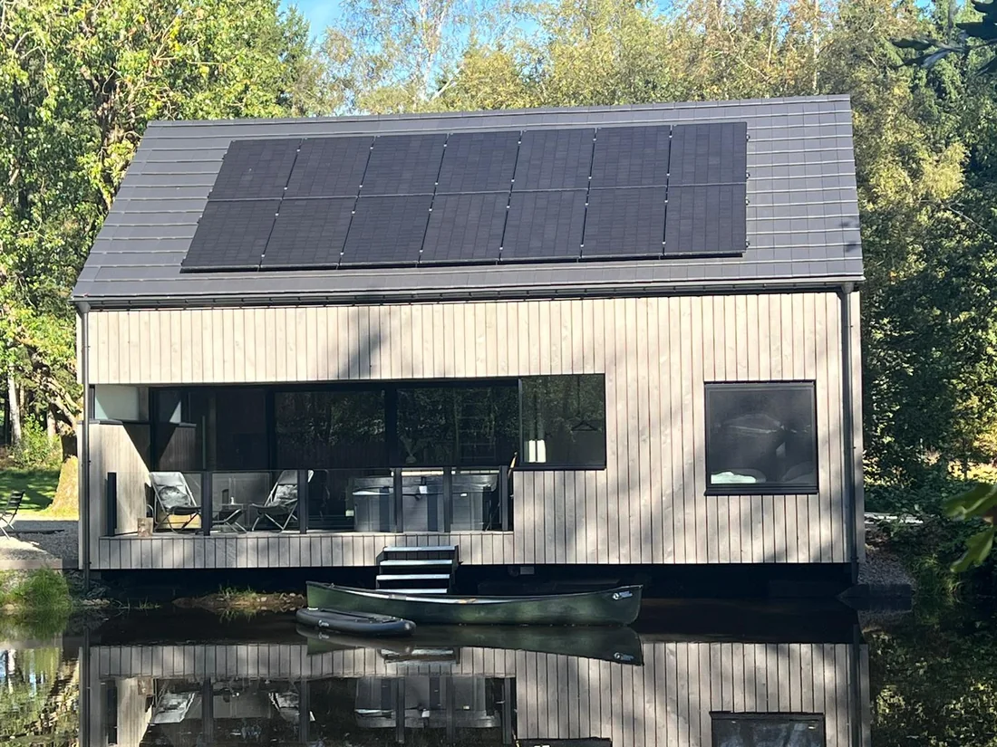 Chalets bardés en pin thermo-traité pré-grisé, pose verticale, au bord de l'eau
