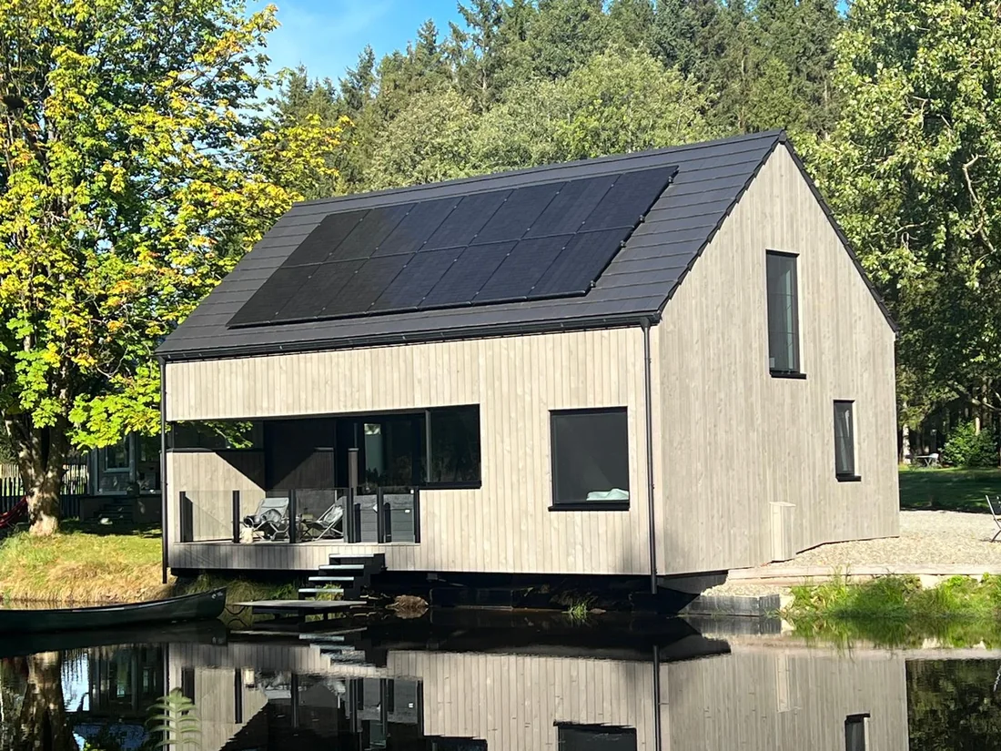 Chalets bardés en pin thermo-traité pré-grisé, pose verticale, au bord de l'eau
