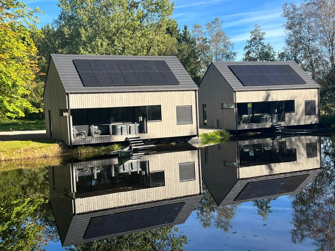 Chalets bardés en pin thermo-traité pré-grisé, pose verticale, au bord de l'eau