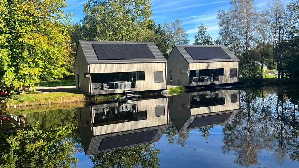 Chalets bardés en pin thermo-traité pré-grisé, pose verticale, au bord de l'eau